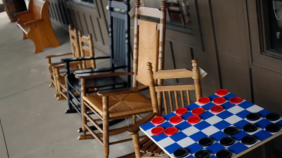 Rocking chairs are displayed for sale alongside a checker board